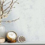 Modern_composition_on_the_shelf_with_dried_flower_in_design_vase,_gold_clock,_accessories_and_decoration._Grey_wall._Copy_space.