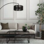 Concrete_living_room_interior_with_gray_sofa,_stylish_black_coffee_table,_green_pouf,__soft_carpet,_braided_pillow,_round_vase_with_leaves,_modern_lamp__and_personal_accessories._Home_decor._Template